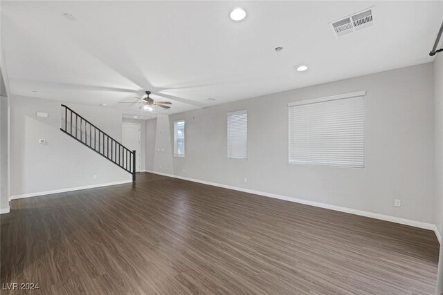 unfurnished living room featuring ceiling fan and dark hardwood / wood-style flooring