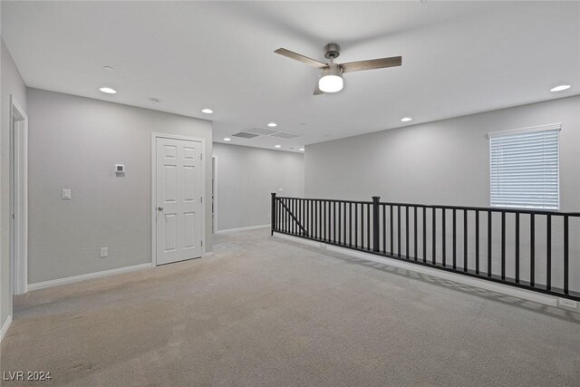 spare room with ceiling fan and light carpet