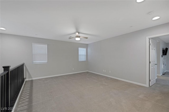 spare room with ceiling fan and light colored carpet