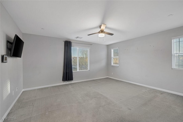 carpeted empty room with ceiling fan and a healthy amount of sunlight