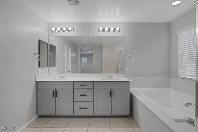 bathroom featuring vanity, tile patterned flooring, and a tub