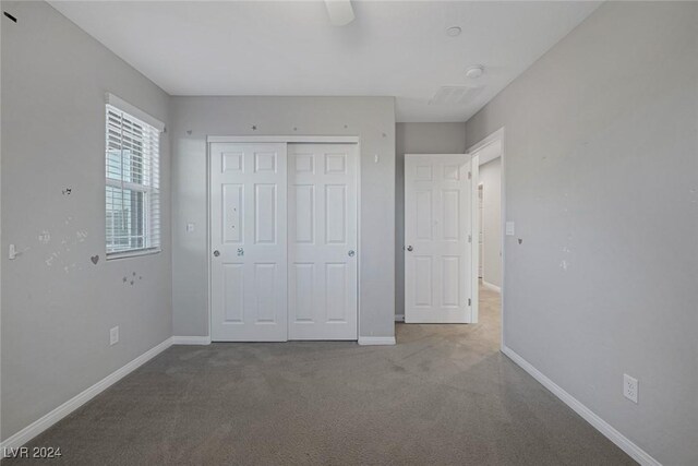 unfurnished bedroom featuring ceiling fan, a closet, and carpet floors