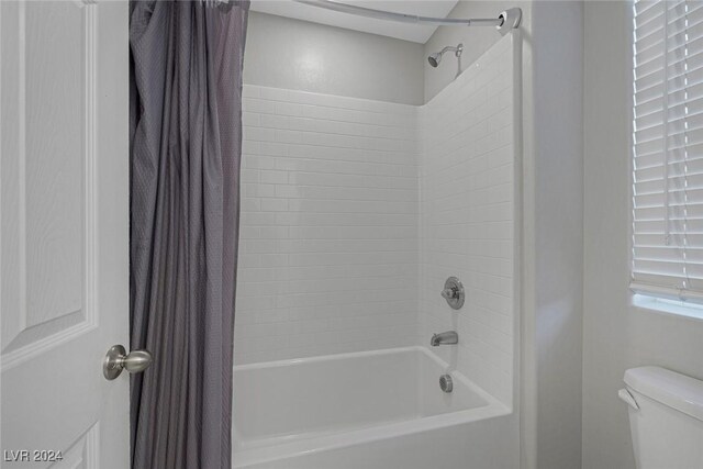 bathroom with toilet and shower / tub combo with curtain