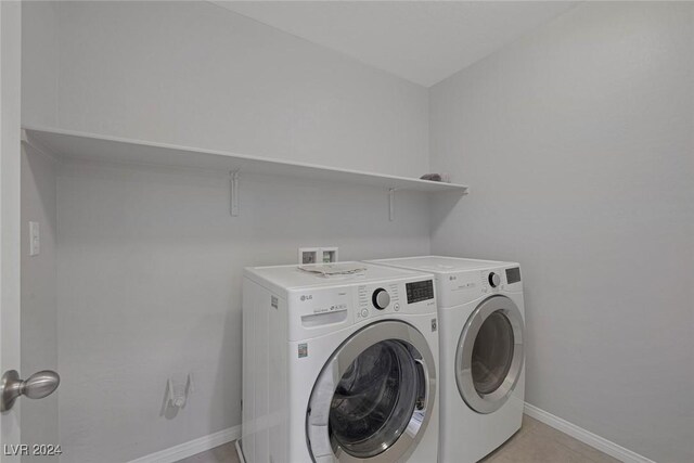 laundry room with light tile patterned floors and washing machine and clothes dryer