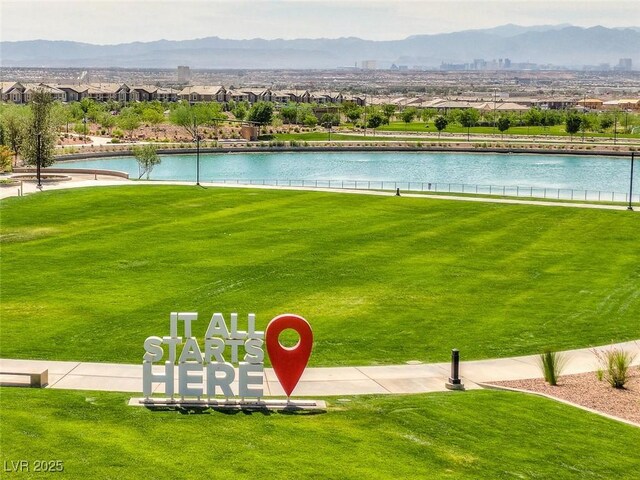 view of home's community with a lawn and a water and mountain view