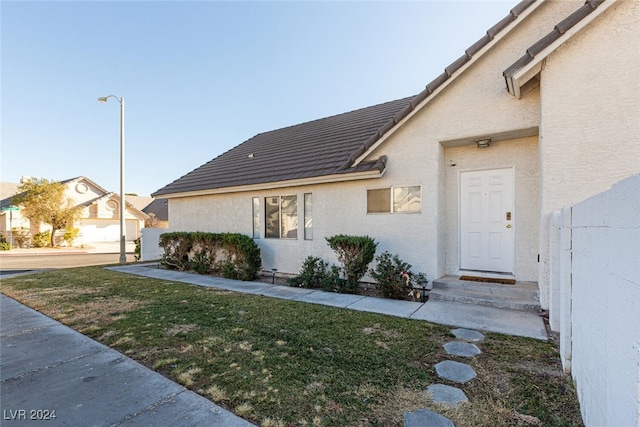 view of exterior entry with a lawn