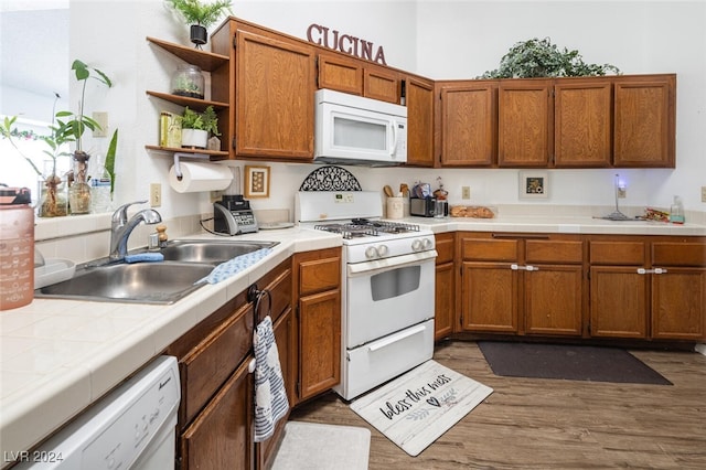 kitchen with white appliances, dark hardwood / wood-style floors, tile counters, and sink