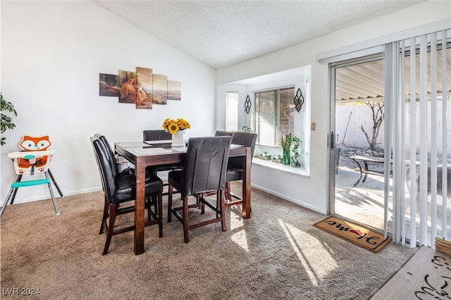 dining area with carpet flooring, a textured ceiling, and vaulted ceiling