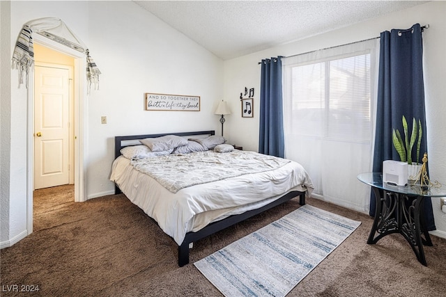 carpeted bedroom featuring a textured ceiling and vaulted ceiling