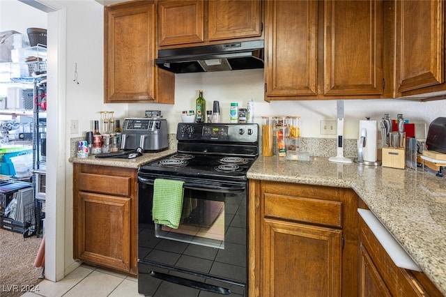 kitchen with light stone counters, black range with electric stovetop, and light tile patterned flooring