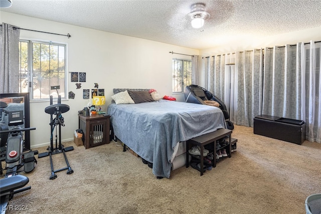 bedroom with carpet, a textured ceiling, and ceiling fan