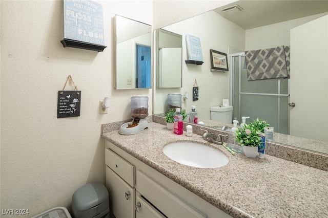 bathroom with vanity, toilet, and an enclosed shower