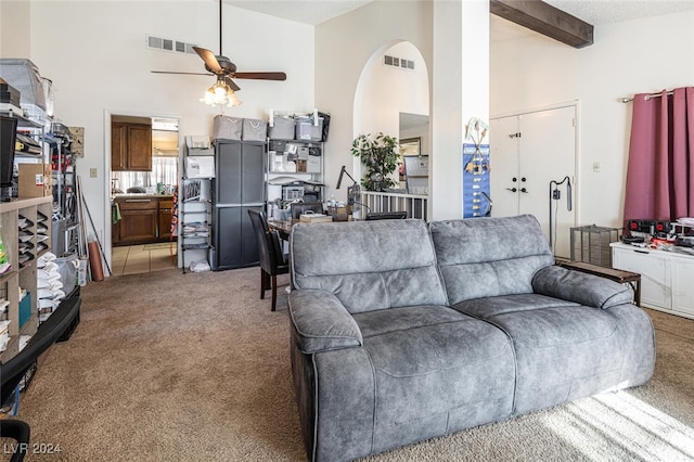 living room featuring carpet, ceiling fan, a towering ceiling, a textured ceiling, and beam ceiling