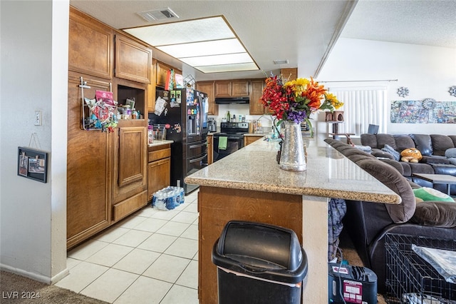 kitchen with light tile patterned flooring, a kitchen breakfast bar, kitchen peninsula, and black appliances