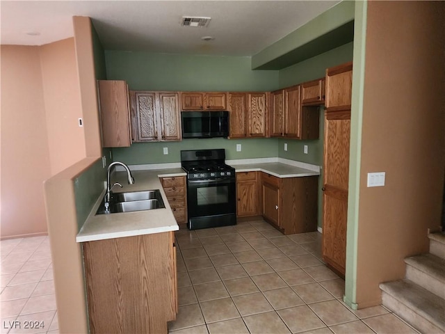 kitchen with sink, light tile patterned floors, and black appliances