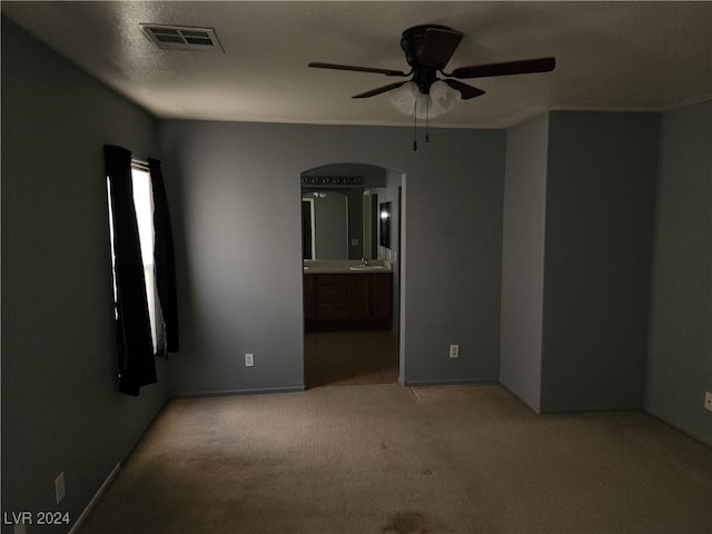 spare room featuring light carpet, ceiling fan, and sink