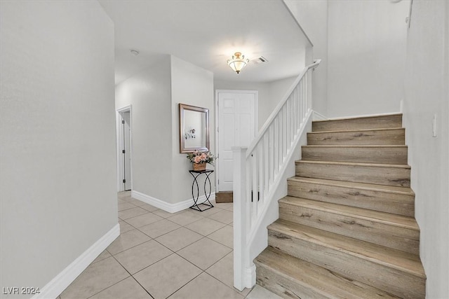 stairway with tile patterned floors