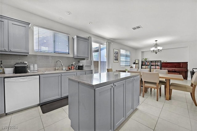 kitchen featuring decorative backsplash, sink, a chandelier, dishwasher, and gray cabinets