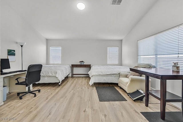 bedroom with lofted ceiling and light hardwood / wood-style flooring