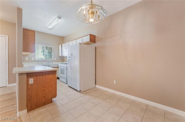 kitchen featuring kitchen peninsula, white appliances, sink, an inviting chandelier, and hanging light fixtures