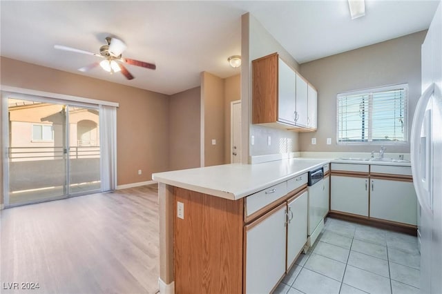 kitchen featuring white cabinets, white dishwasher, light hardwood / wood-style flooring, ceiling fan, and kitchen peninsula