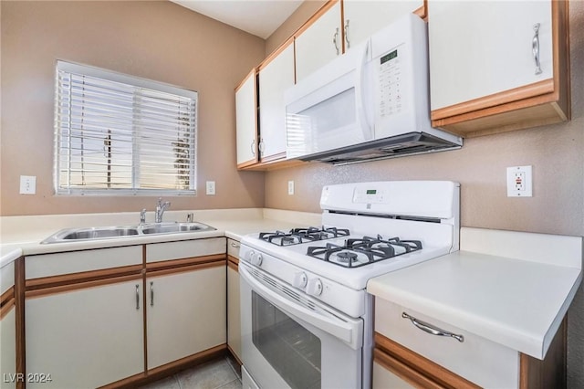 kitchen featuring white cabinets, light tile patterned flooring, white appliances, and sink