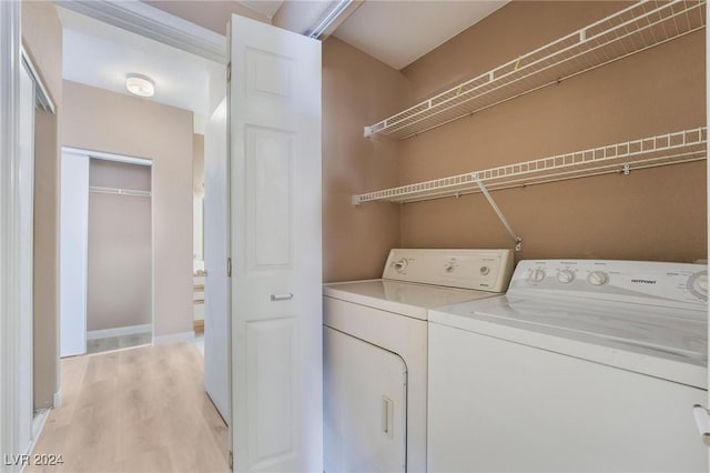 laundry area featuring washer and dryer and light hardwood / wood-style flooring