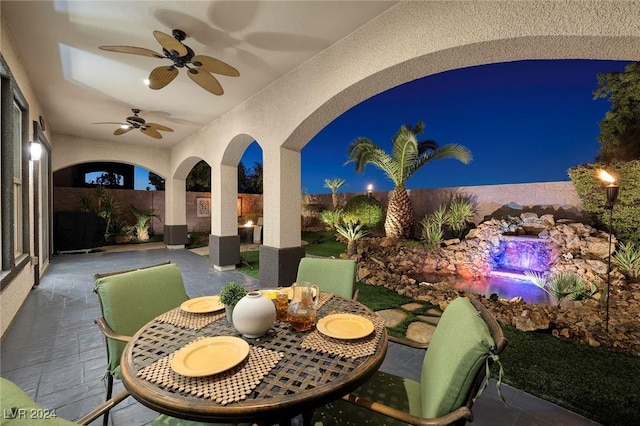 patio at night featuring ceiling fan