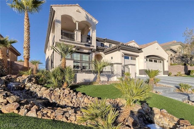 mediterranean / spanish-style home featuring a garage and a balcony