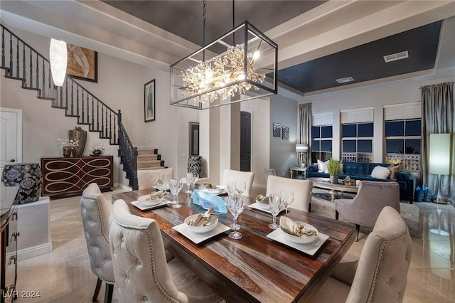 dining space with a raised ceiling, light tile patterned flooring, and a notable chandelier