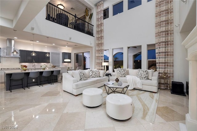 living room featuring beamed ceiling, a towering ceiling, and sink