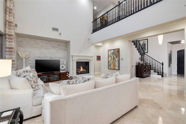 living room with a large fireplace and a high ceiling