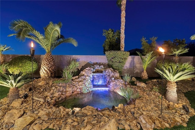 view of pool at twilight