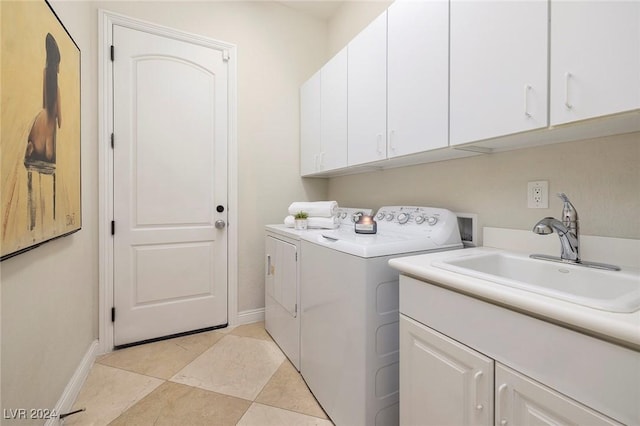 laundry room featuring washing machine and clothes dryer, sink, and cabinets