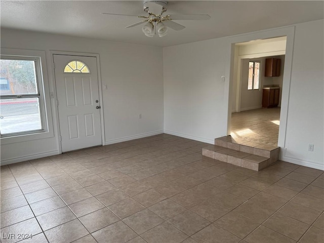 foyer entrance with light tile patterned floors and ceiling fan