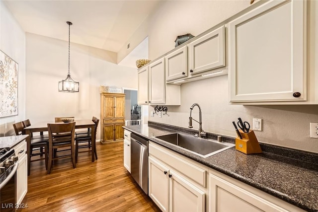 kitchen with hardwood / wood-style floors, an inviting chandelier, sink, hanging light fixtures, and stainless steel appliances