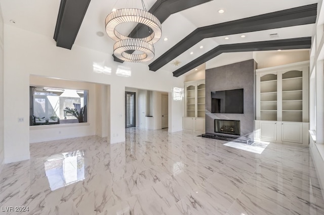 unfurnished living room with a notable chandelier, lofted ceiling with beams, built in features, and a premium fireplace