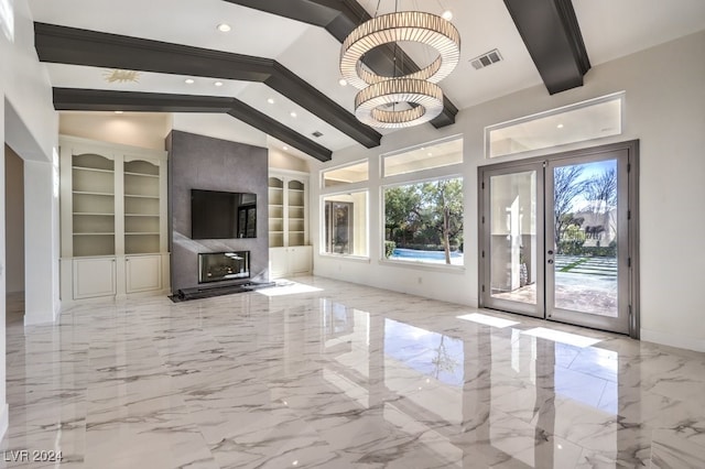 unfurnished living room featuring french doors, built in shelves, an inviting chandelier, a fireplace, and vaulted ceiling with beams