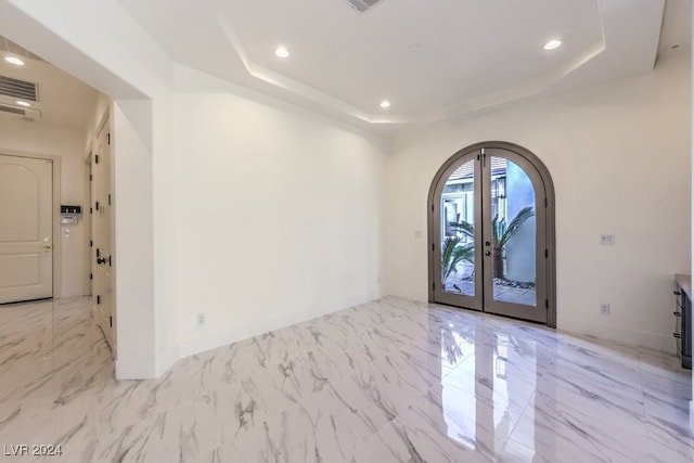 entrance foyer with a raised ceiling and french doors