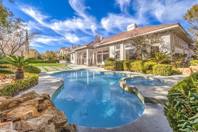 view of swimming pool with a patio area and an in ground hot tub