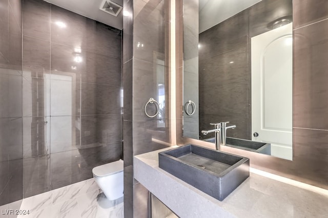 bathroom with toilet, tile walls, and sink