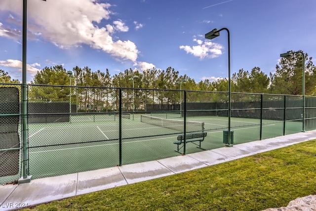 view of tennis court featuring a yard