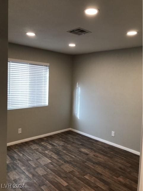 unfurnished room with dark wood-type flooring