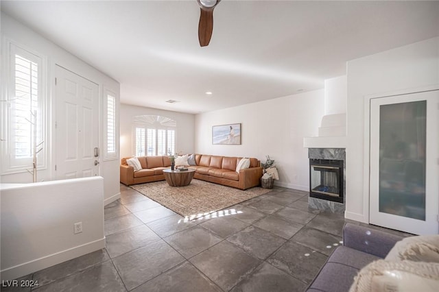 living room with a multi sided fireplace and ceiling fan