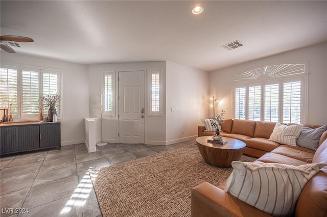 living room featuring a wealth of natural light, radiator heating unit, and ceiling fan