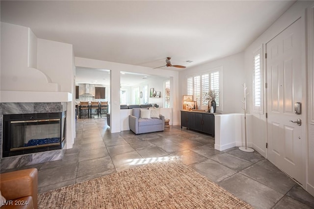 living room featuring ceiling fan and a high end fireplace