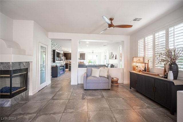 interior space with ceiling fan and a high end fireplace