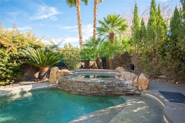 view of pool featuring an in ground hot tub