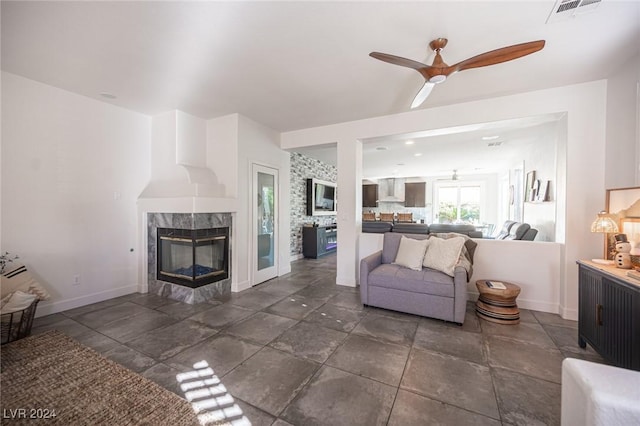 living room featuring ceiling fan and a fireplace