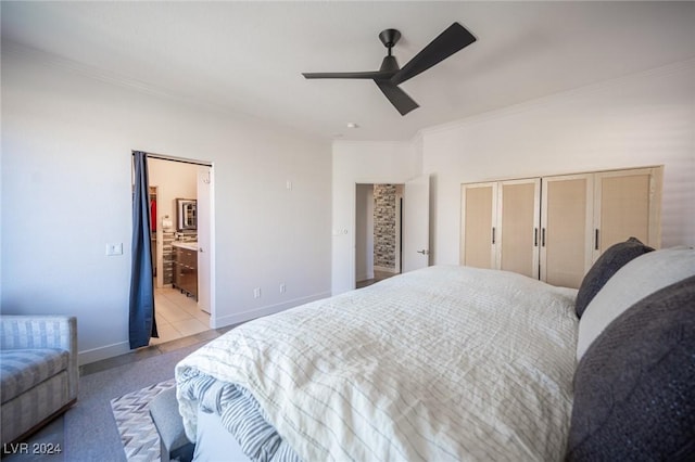 bedroom featuring light tile patterned floors, connected bathroom, ceiling fan, and crown molding